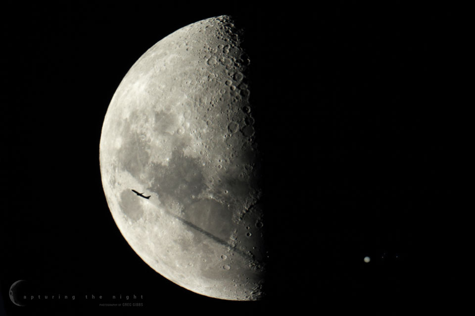 Der Halbmond im Bild ist kurz davor, den Planeten Jupiter zu bedecken. Währenddessen flog ein Flugzeug vor dem Mond vorbei.