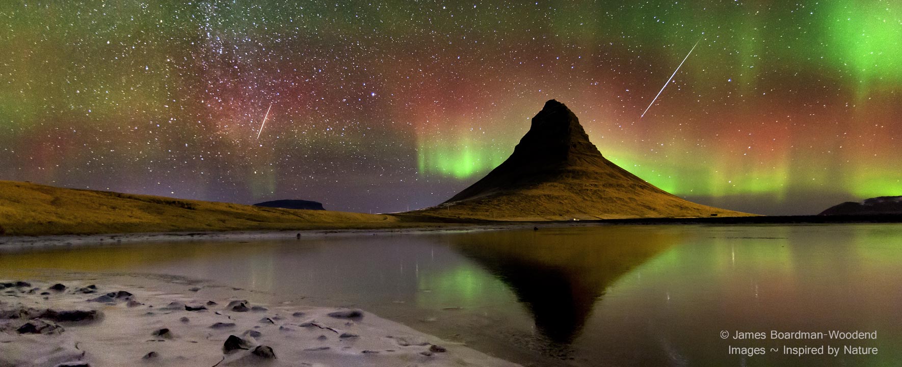 Hnter dem Vulkan Kirkjufell im Westen von Island nahe der Stadt Grundarfjörður leuchten zarte Polarlichter. Einige Meteore der Geminiden zischen durchs Bild.