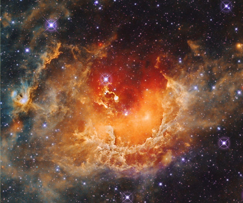 Der Nebel im Bild erinnert an eine zu uns geöffnete Höhlung. In der Mitte sind zwei hell leuchtende Staubwülste, es sind die Kaulquappen IC 410. Der Emissionsnebel ist in den Sternhaufen NGC 1893 eingebettet.