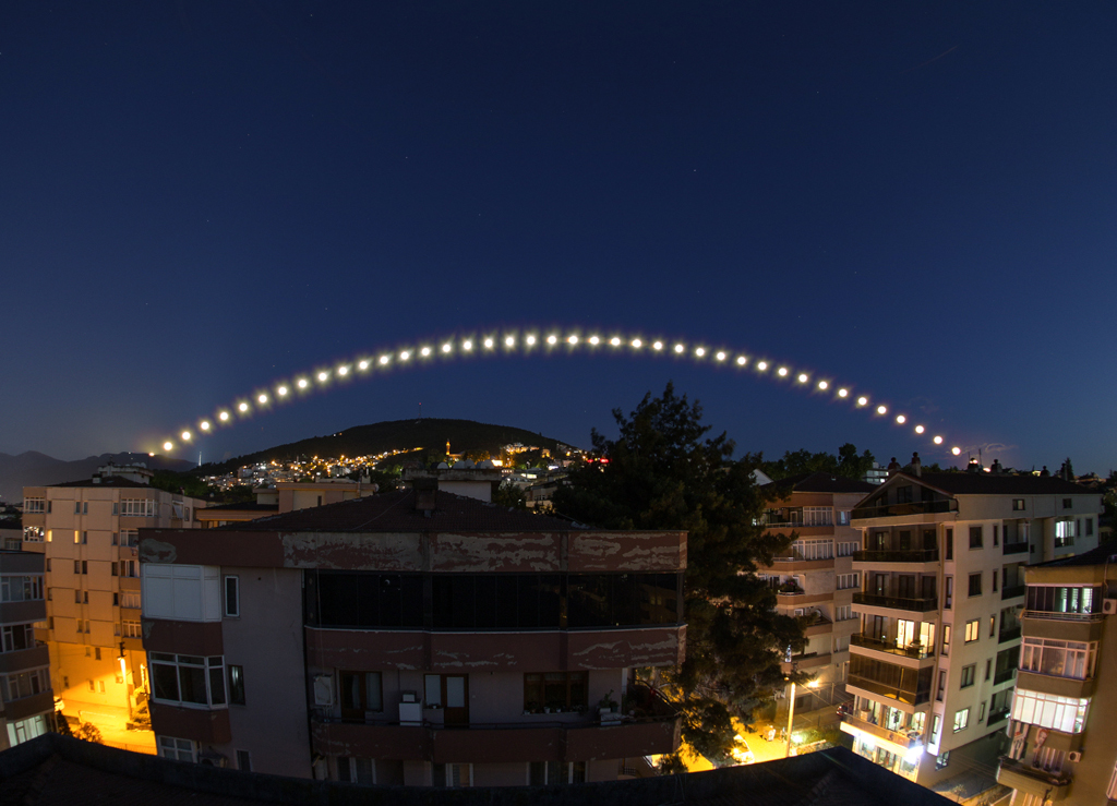 Über einer Stadt verläuft in einem Bogen der Juni-Vollmond, der in der Nacht des 21. Juni über der türkischen Stadt Bursa alle 10 Minuten fotografiert wurde.