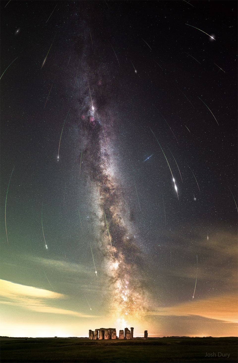 Über dem berühmten astronomischen Monument Stonehenge in England steigt die Milchstraße fast senkrecht auf. Vom Himmel fallen Meteore der Perseïden, ihre Bahnen sind leicht gekrümmt wegen des verwendeten Weitwinkelobjektivs.