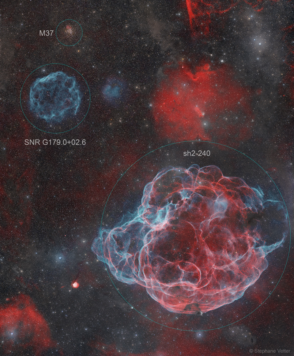 In einem Sternfeld mit mehreren Nebeln befindet sich links oben ein eckiger, kleiner blauer Supernova-Überrest. Rechts unten dominiert ein großer Supernova-Überrest in Rot und Blau.